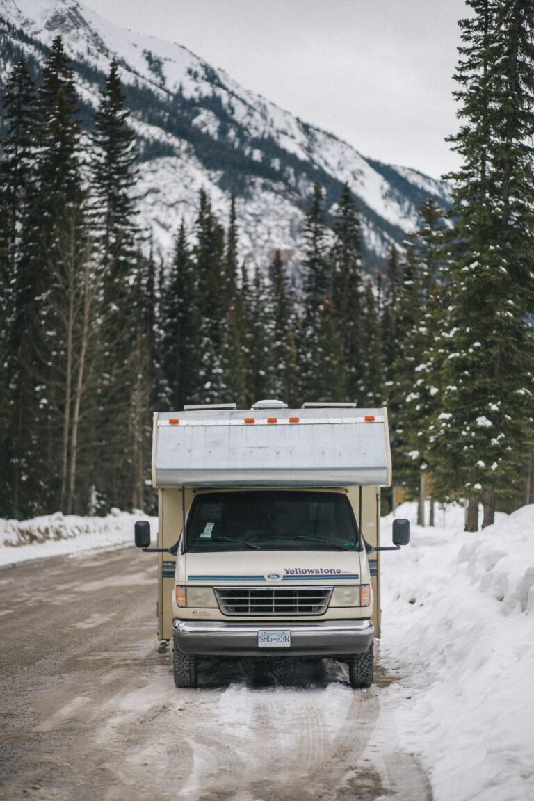 An RV parked in snowy Banff National Park with mountain backdrop.
