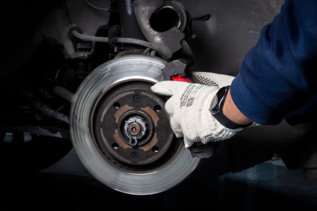 Bremsfading Wohnmobil - Mechanic working on brake system in a workshop setting.
