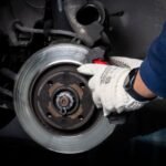 Bremsfading Wohnmobil - Mechanic working on brake system in a workshop setting.