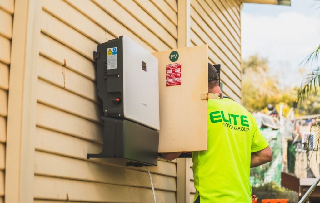 Electrician from Elite Power Group installing a solar inverter outside. Wechselrichter Wohnmobil
