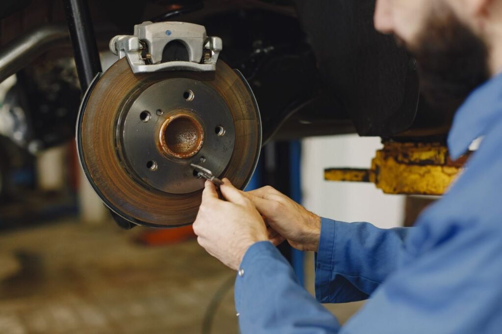 Mechanic working on brake disc in an repair workshop, close-up, focus on hands. - Bremsfading Wohnmobil 