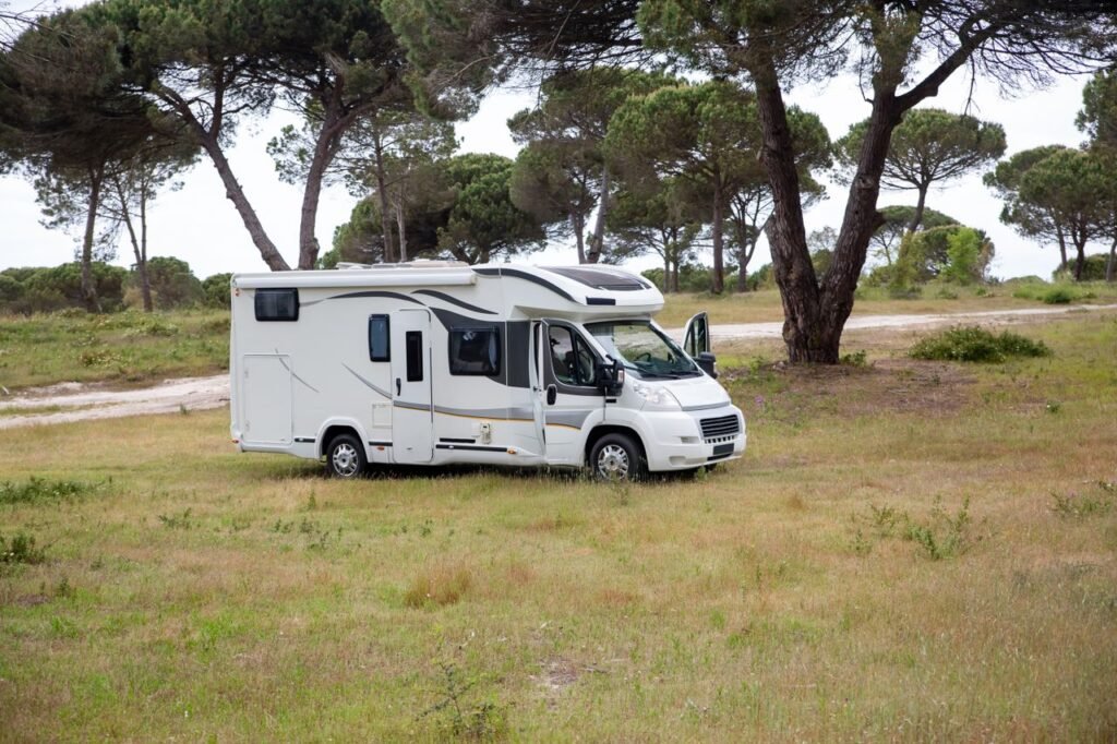 Captivating shot of a campervan amidst a serene field in Portugal, surrounded by trees. Wassertank Wohnmobil