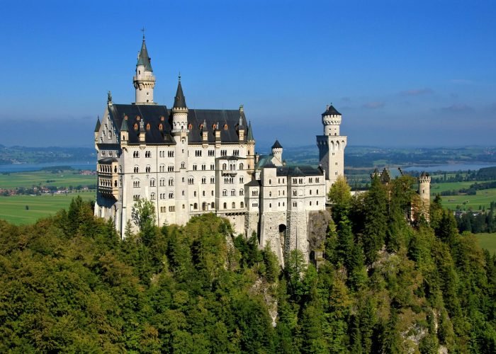 pexels-photo-187854-187854 Aerial view of the iconic Neuschwanstein Castle surrounded by lush greenery in Bavaria, Germany.