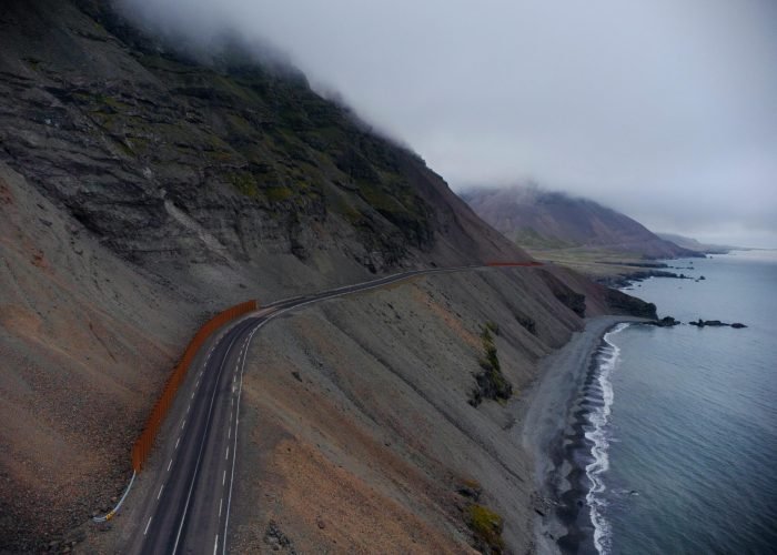 A breathtaking aerial view of a coastal road in Iceland, featuring dramatic landscapes and moody skies. A breathtaking aerial view of a coastal road in Iceland, featuring dramatic landscapes and moody skies.