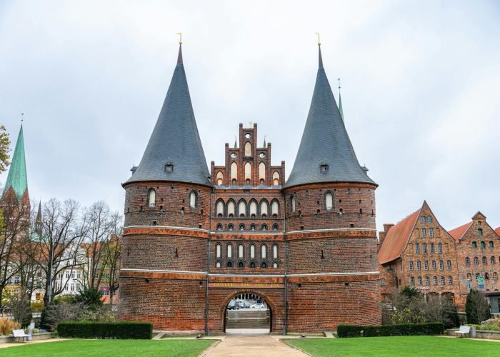 Front view of the iconic Gothic Holstentor Gate in Lübeck, Germany, a symbol of medieval architecture. Front view of the iconic Gothic Holstentor Gate in Lübeck, Germany, a symbol of medieval architecture.