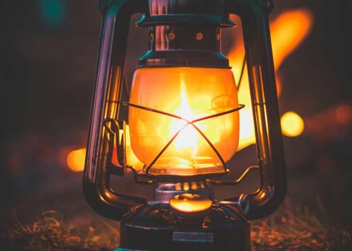 pexels-photo-3163877-3163877 A classic illuminated lantern casting warm glow amidst night setting.
